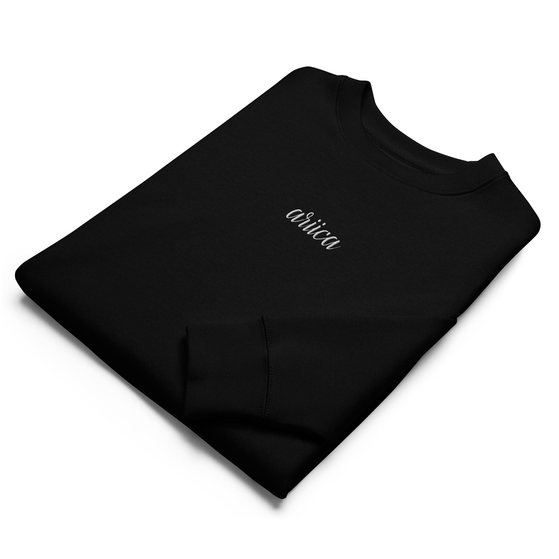 Folded Black Organic Sweatshirt with white Embroidery, featuring minimalist luxury and sustainable craftsmanship.