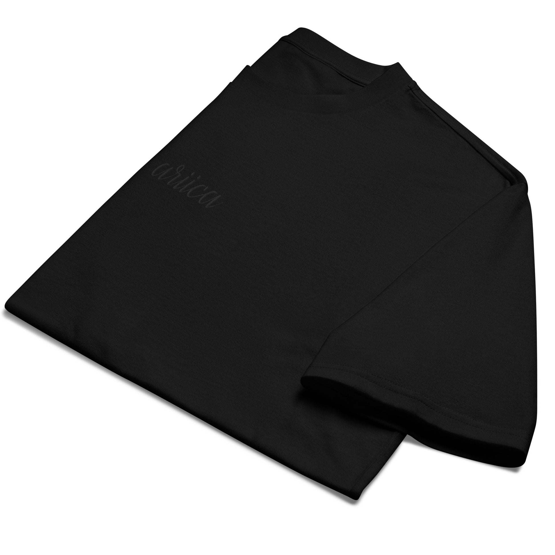 Folded Oversized Black Heavyweight Tee with black Embroidery, emphasizing minimalist design and high-quality fabric