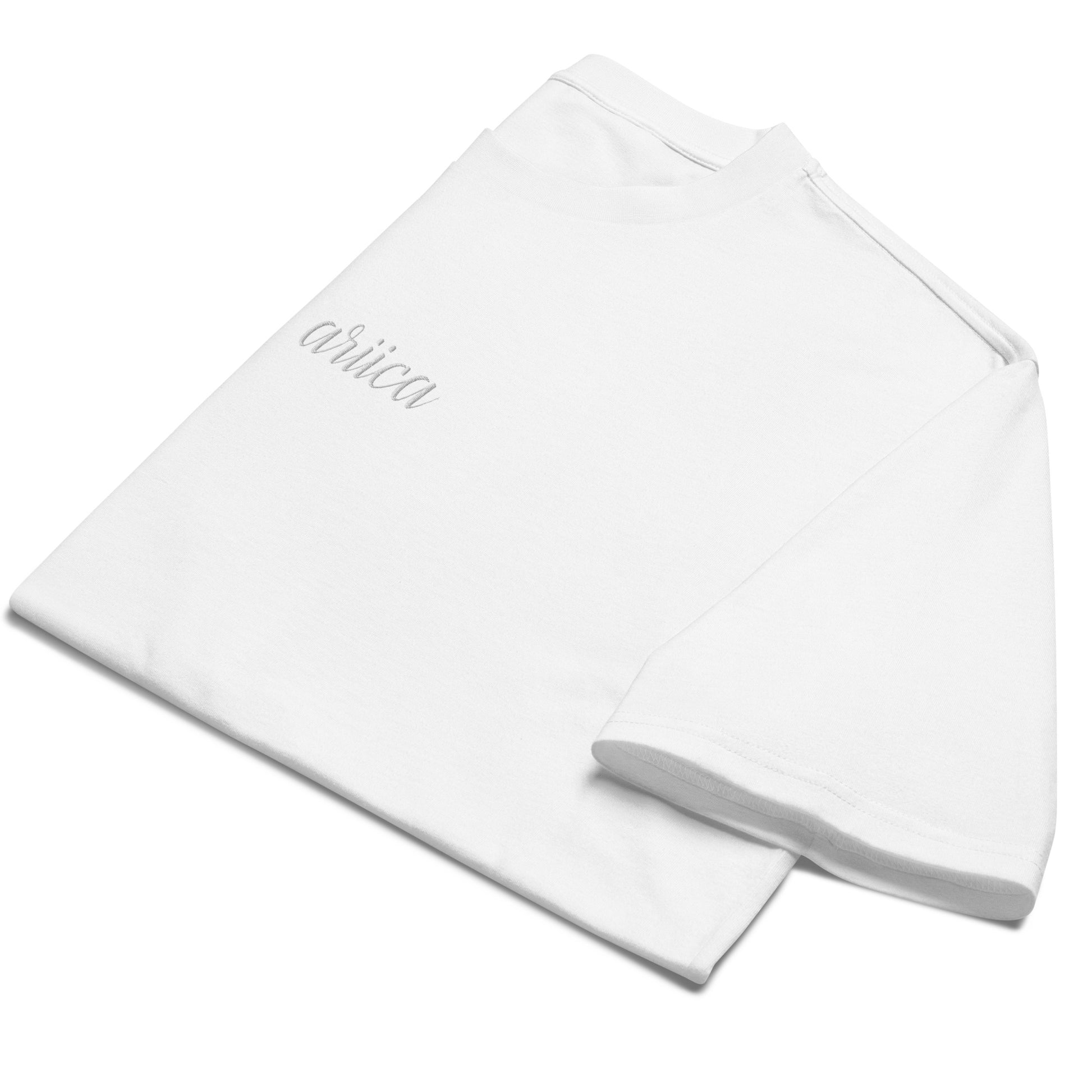 Folded Oversized White Heavyweight Tee with white Embroidery, emphasizing minimalist design and high-quality fabric